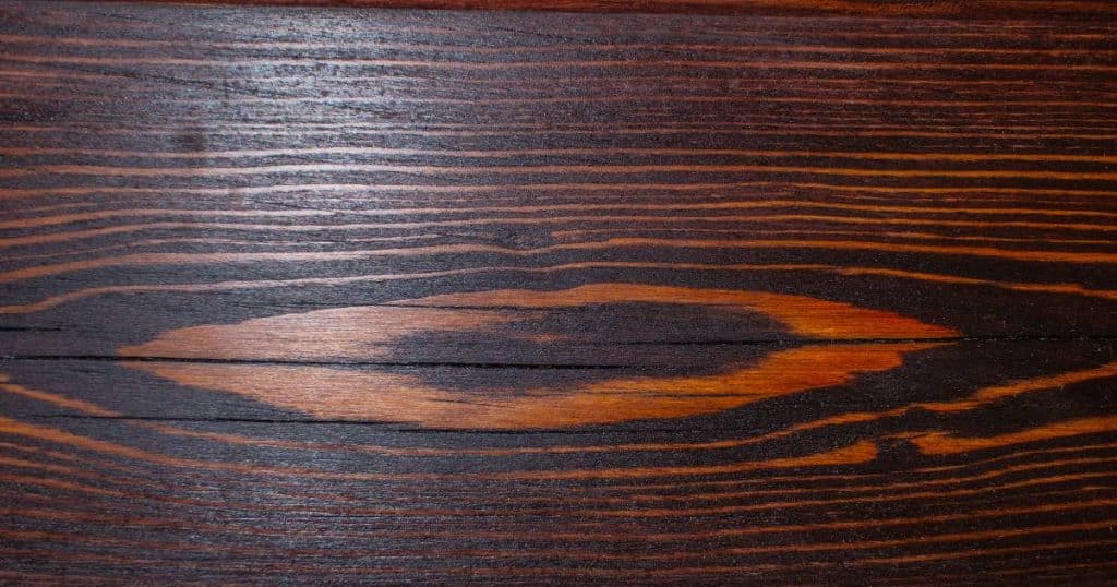 Bovenaanzicht van wengé plank met kenmerkende bruine en bijna zwarte strepen. 