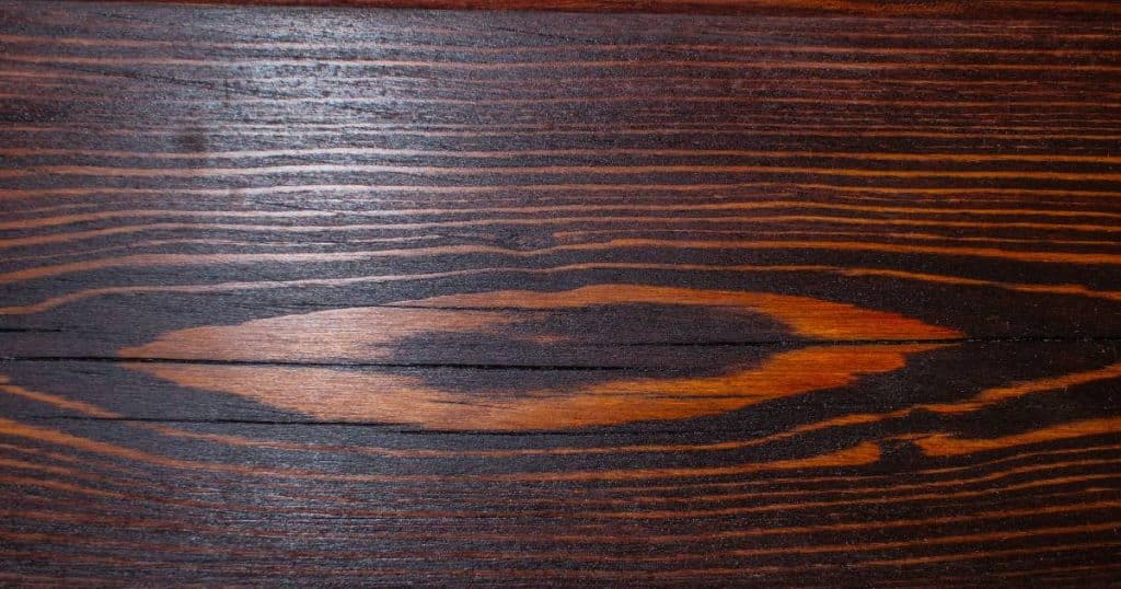 Bovenaanzicht van wengé plank met kenmerkende bruine en bijna zwarte strepen. 