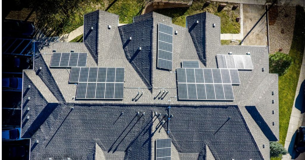 Een dak van een grote woning met zonnepanelen.