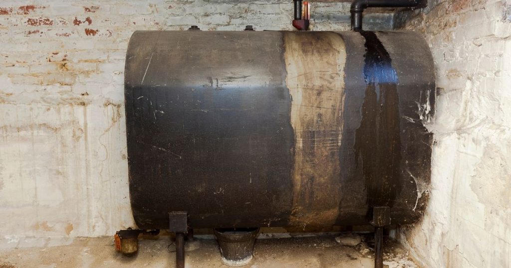 Een oude, bovengrondse mazouttank of stookolietank in een witte kelder.