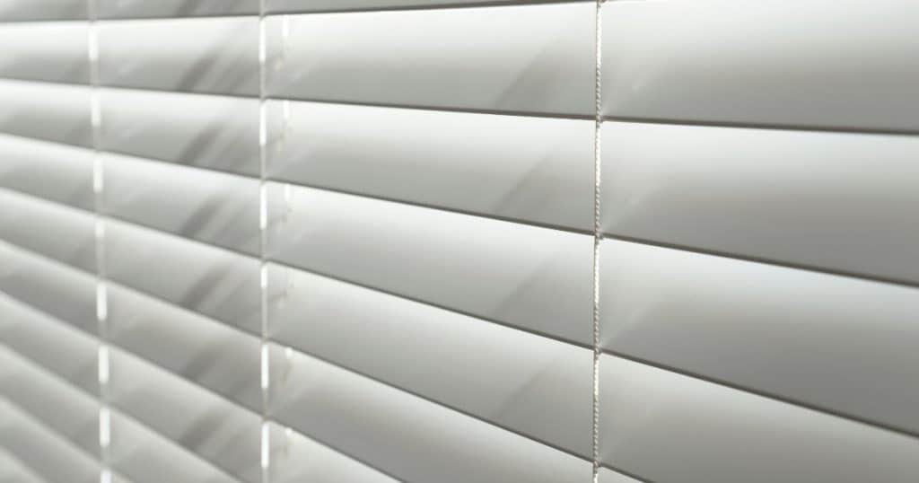 Close-up van witte pvc of kunststof rolluiken met kantelbare lamellen.