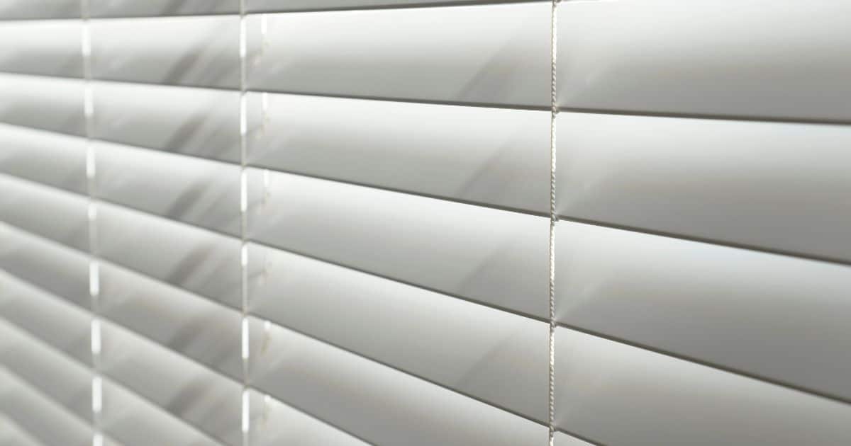 Close-up van witte pvc of kunststof rolluiken met kantelbare lamellen.