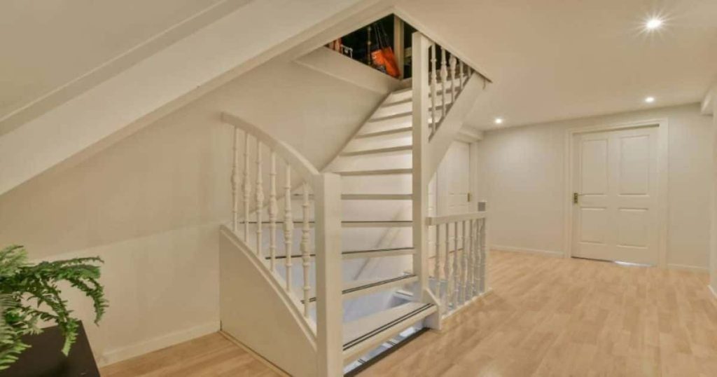 Witte houten trap met typische jaren '30 look. De witte spijlen van de trapleuning hebben een klassiek design.