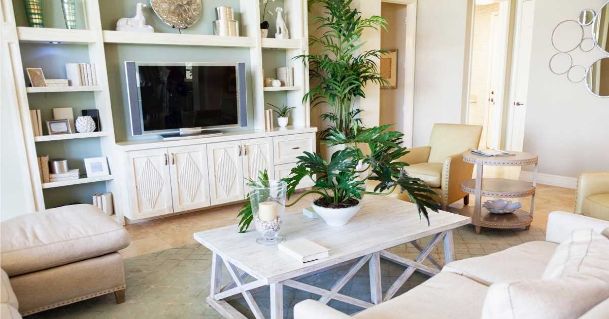 Een woonkamer met tv-meubel en kastenwand, ingericht met boeken, televisietoestel en decoratieve objecten.