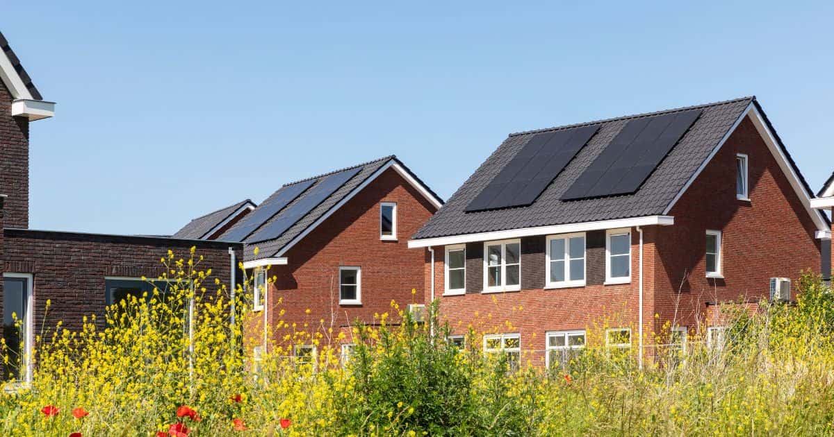 Een wijk met moderne woningen in Sint-Niklaas hebben zonnepanelen op het dak. Elke installatie telt minstens 9 panelen.