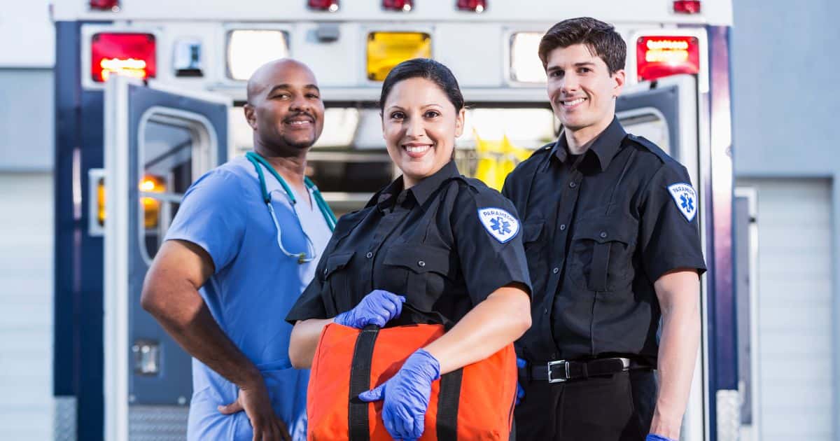 Een team vriendelijke ambulanciers voor een ziekenwagen.
