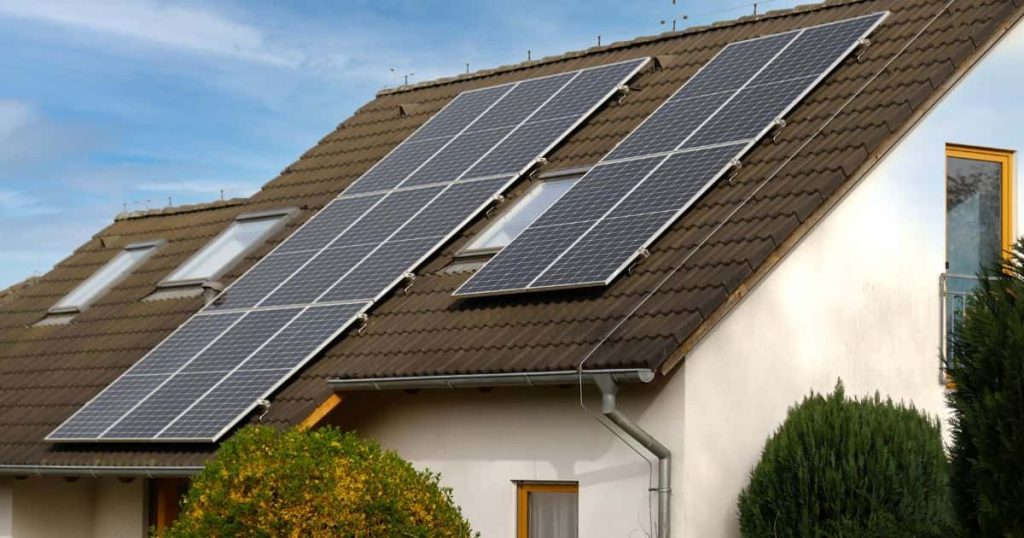 Een groot wit huis in de provincie Waals-Brabant met schuin dak met zonnepanelen.