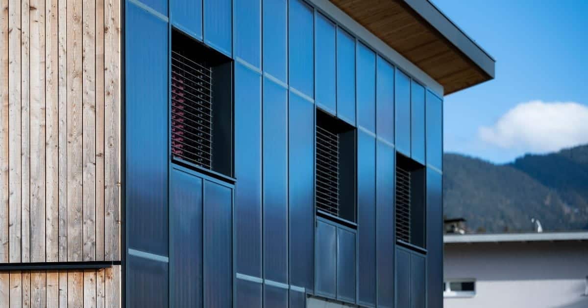 Zwarte gevel zonnepanelen gemonteerd op een modern gebouw met zonlichtreflectie op de panelen