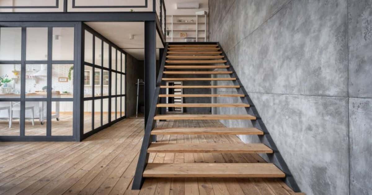 Industriele houten trap met open treden en zwarte stalen trapboom.