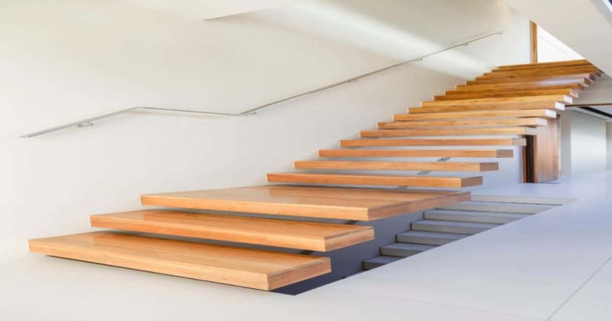 Houten luie, zwevende, steile trap in een neutrale witte woning.