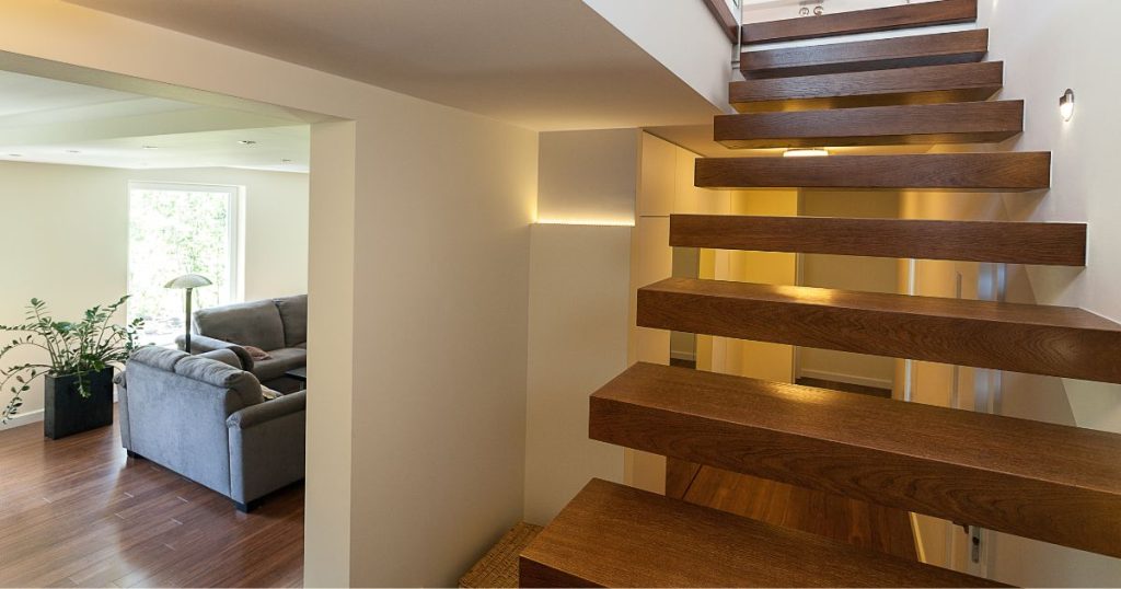 Een zwevende houten trap met trapverlichting die men op maat heeft laten maken.