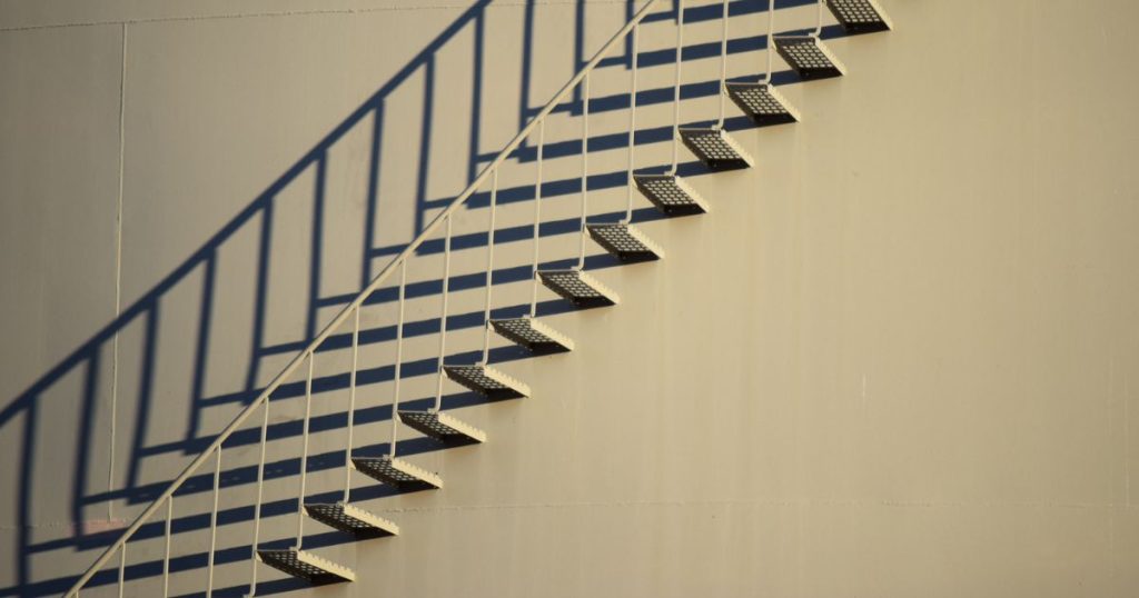 Een zwevende stalen trap die rechtstreeks aan de wand is bevestigd. De open traptreden bieden extra ondersteuning bij regen, sneeuw of andere omstandigheden. Ook de trapleuning zelf is van staal.